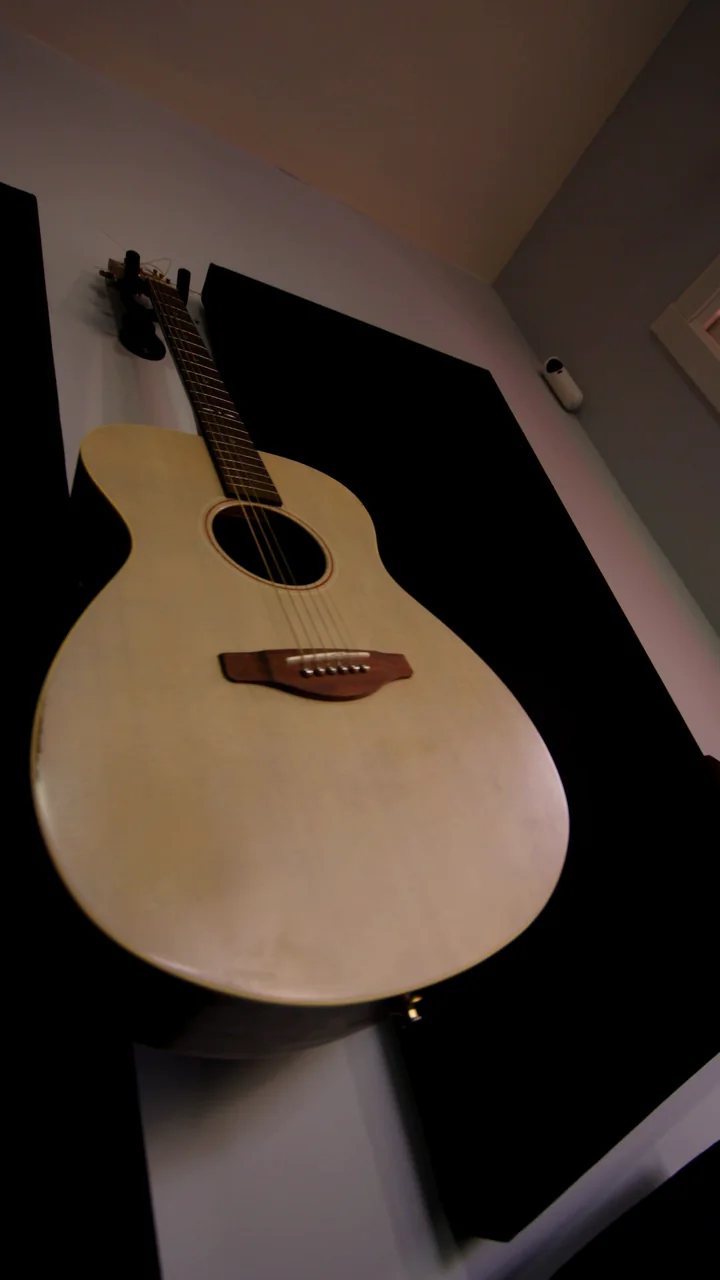 Una guitarra acústica colgada en la pared